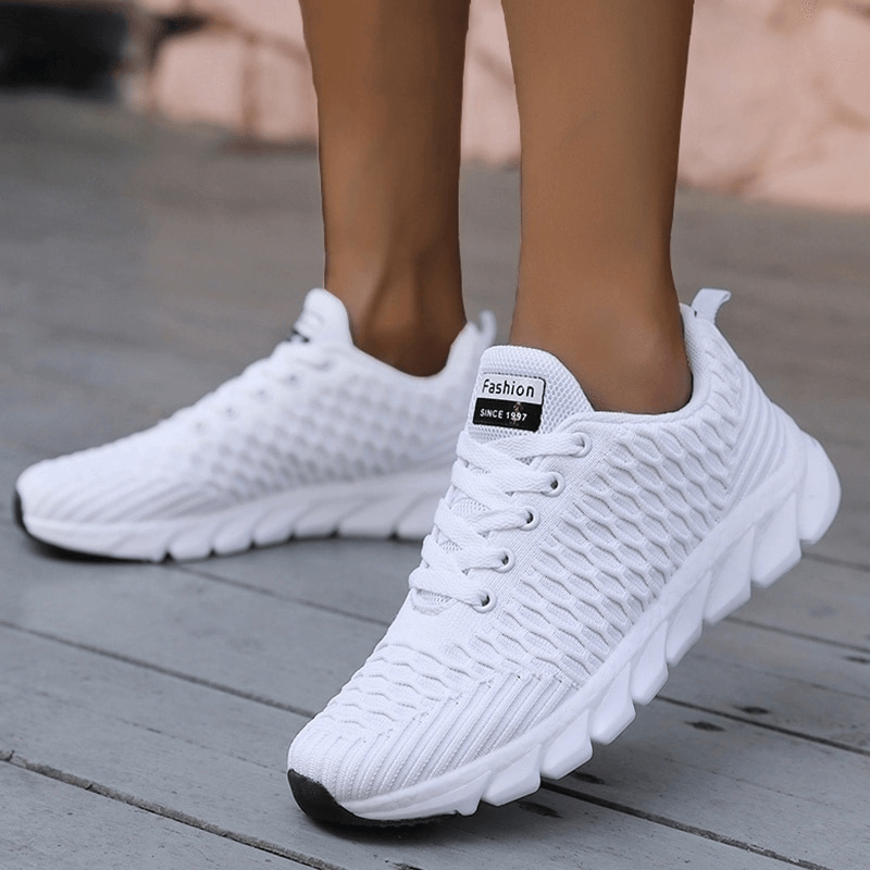 White lightweight mesh flexible women's running shoes with EVA cushioning and lace-up closure, perfect for comfort during workouts.