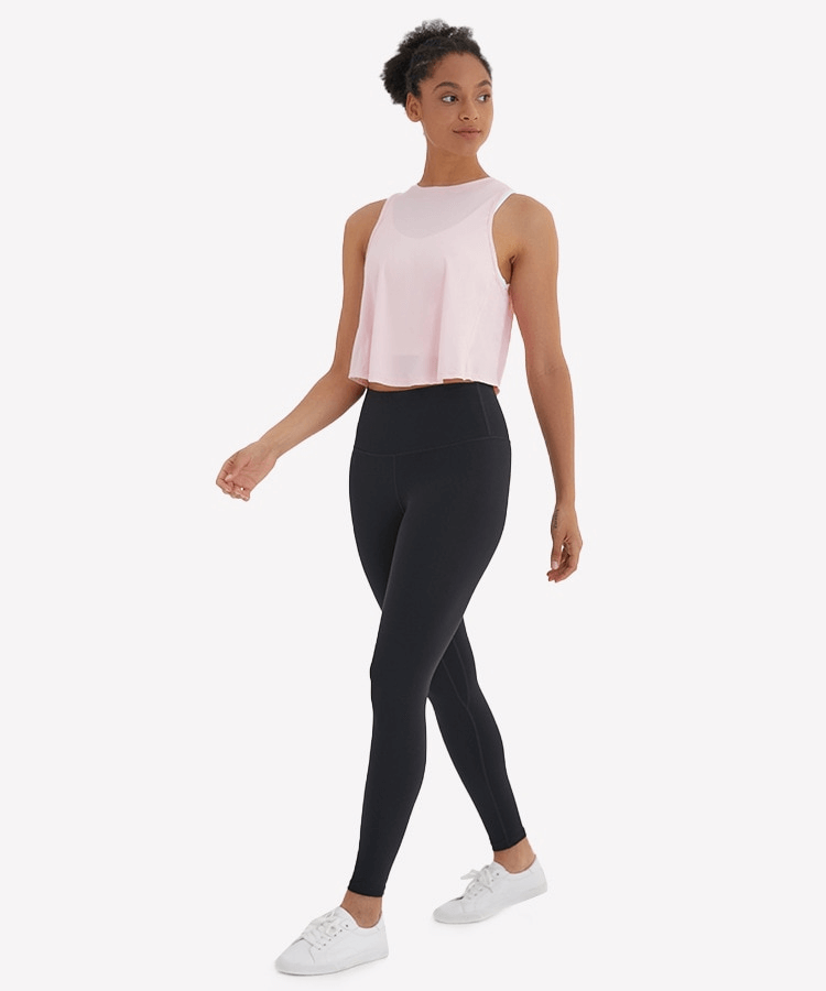 Woman in activewear wearing a lightweight, quick-dry sleeveless t-shirt with mesh back, perfect for exercise, yoga, and sports.