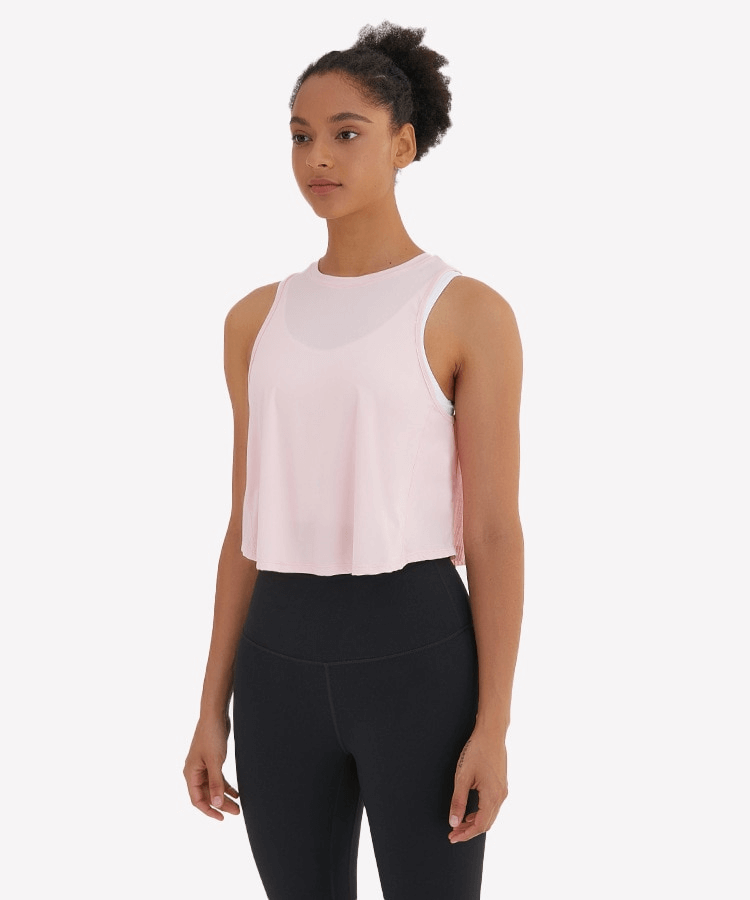Model wearing a lightweight quick-dry women's sleeveless t-shirt with mesh back, perfect for workouts and yoga.