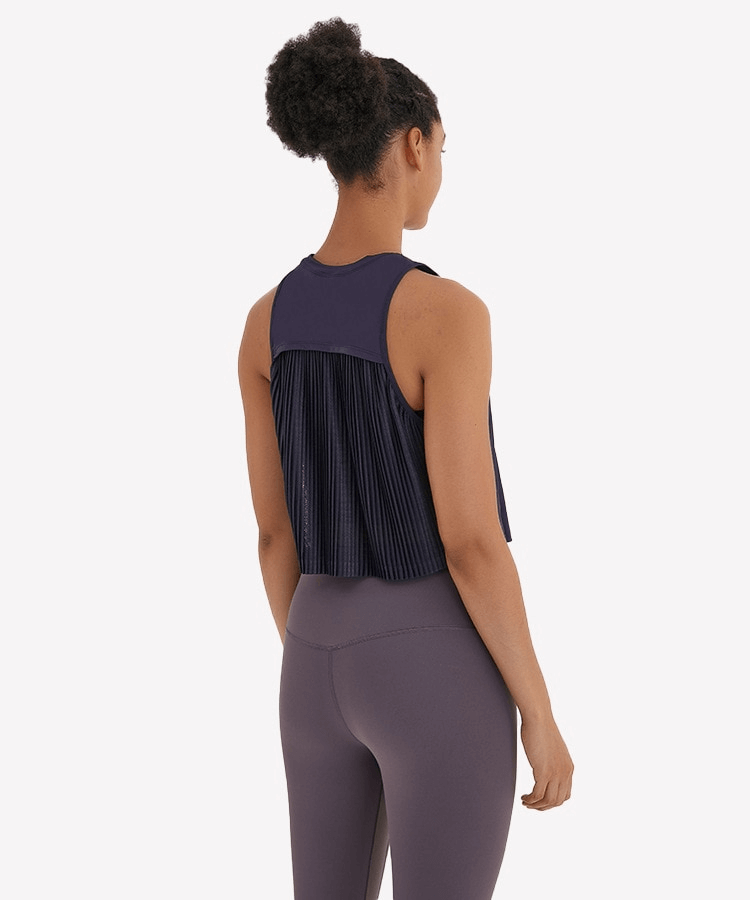 Woman wearing a lightweight quick dry sleeveless t-shirt with mesh back, ideal for running and yoga. Stylish activewear.