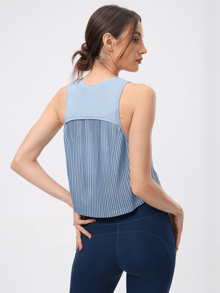 Woman wearing a blue sleeveless t-shirt with mesh back, perfect for workouts and yoga. Lightweight, quick-dry, and stylish activewear.