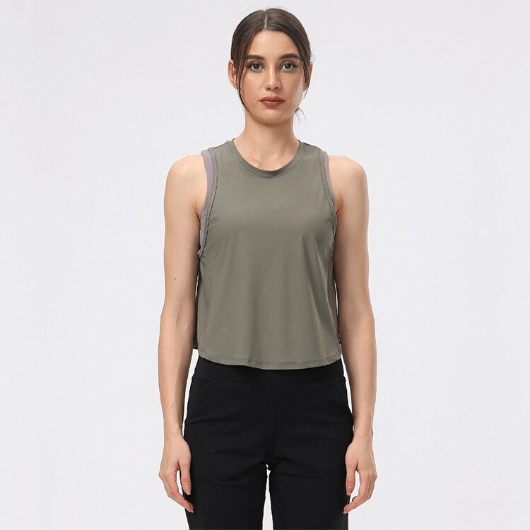 Woman wearing lightweight quick dry sleeveless t-shirt with mesh back, ideal for workouts like running and yoga. Anti-wrinkle fabric.