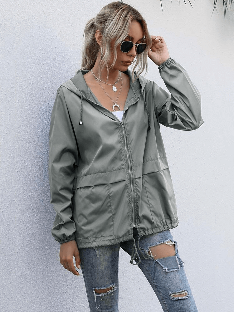 Model wearing lightweight waterproof women's jacket windbreaker with hood, V-neck collar, and pockets, paired with jeans.