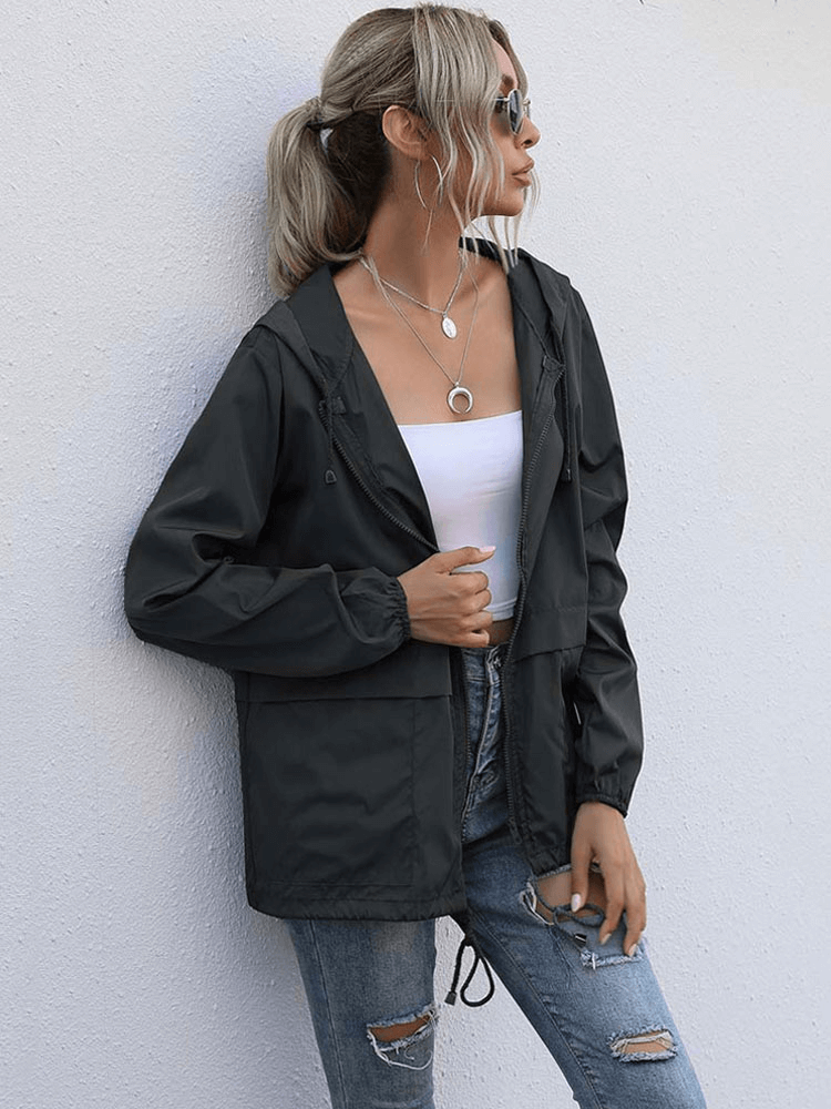 Woman wearing a lightweight waterproof sport women's jacket windbreaker with hood, V-neck collar, and zipper closure.