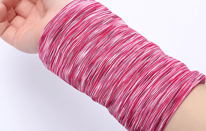 Close-up of a pink and white striped sports wristlet, showcasing its stretchy and breathable material, perfect for holding essentials during workouts.