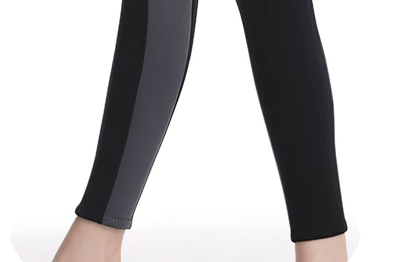 Close-up of black neoprene wetsuit leggings for snorkeling and surfing, featuring a sleek design with gray side panel.