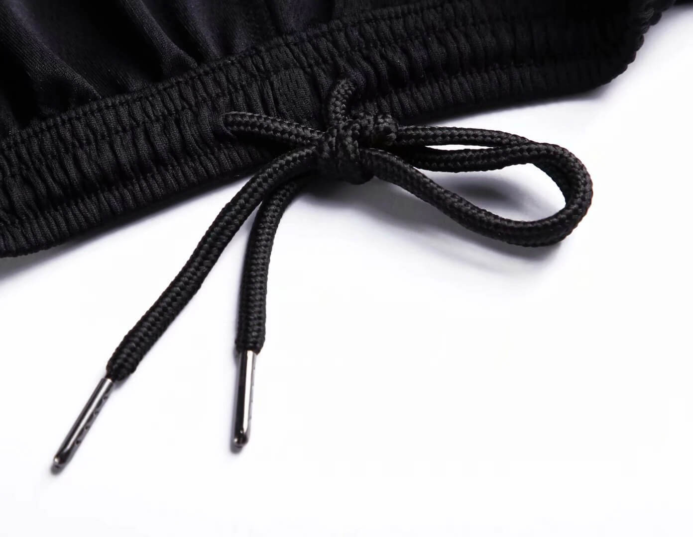 Close-up of black elastic waistband with adjustable drawstring on loose basketball shorts for men, showcasing quality sportswear design.