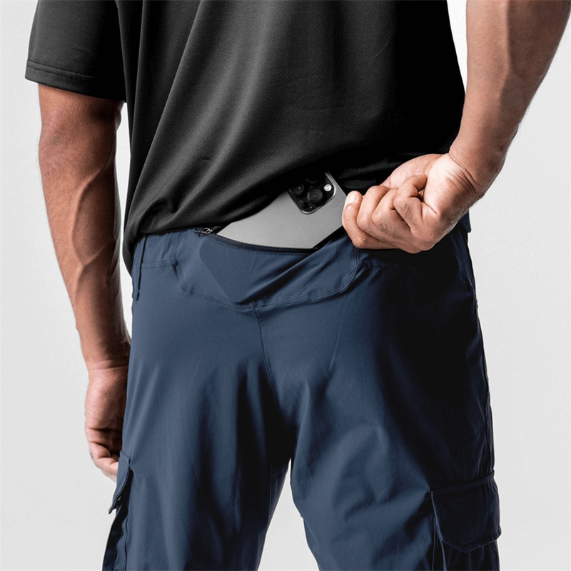 Man wearing loose slim elastic joggers, showing concealed pocket in navy pants designed for men's comfort and style.