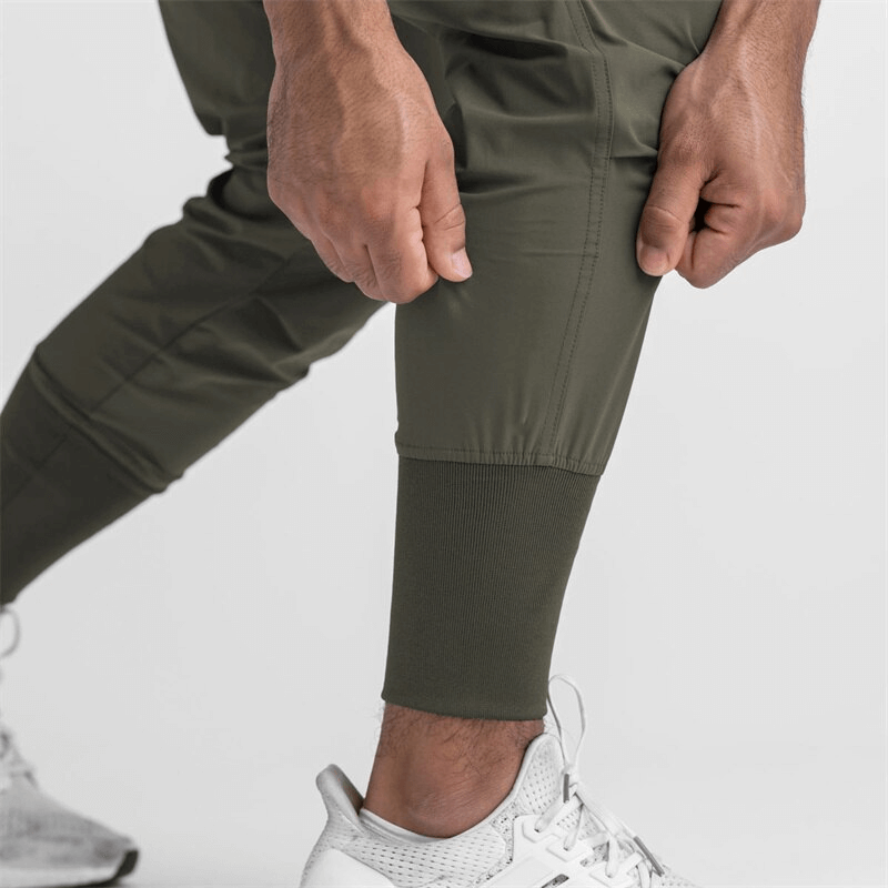 Close-up of men's loose slim elastic joggers with wide cuffs, perfect for running and exercise. Lightweight, breathable polyester.