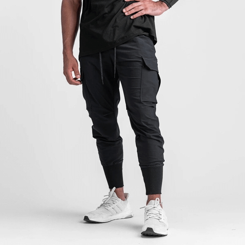 Men's loose slim elastic joggers with wide cuffs, perfect for running and exercise, shown in black with drawstring and athletic fit.