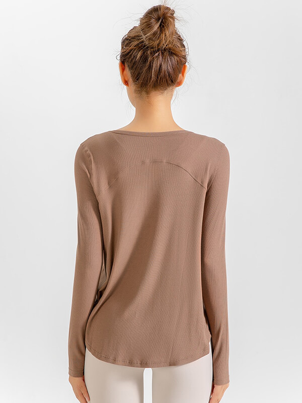 Back view of a woman wearing a natural color loose V-neck top, ideal for running or yoga, featuring long sleeves and quick-dry fabric.