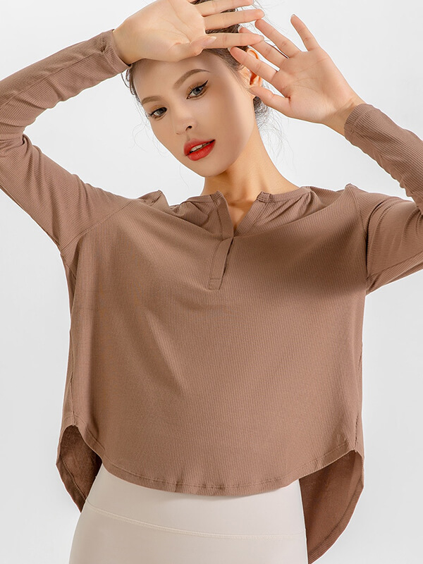 Woman wearing a loose, quick-dry V-neck top in natural color, perfect for yoga or running, showcasing stylish comfortable activewear.