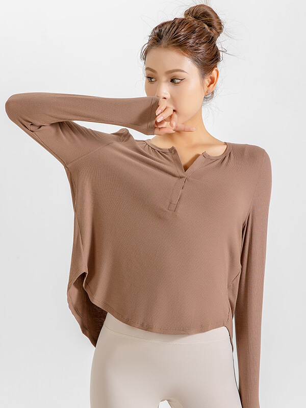 Woman wearing a loose V-neck top in natural color, ideal for yoga and running, made of quick-dry polyester-spandex blend with ribbons.
