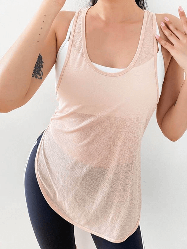 Woman wearing a loose, breathable women's gym tank top in light pink for running and fitness activities. Style SF0029.