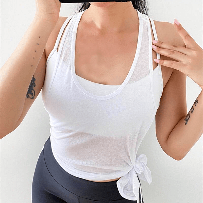 Woman wearing a white loose-fitting gym tank top perfect for running and workouts, showcasing the breathable and quick-dry fabric.