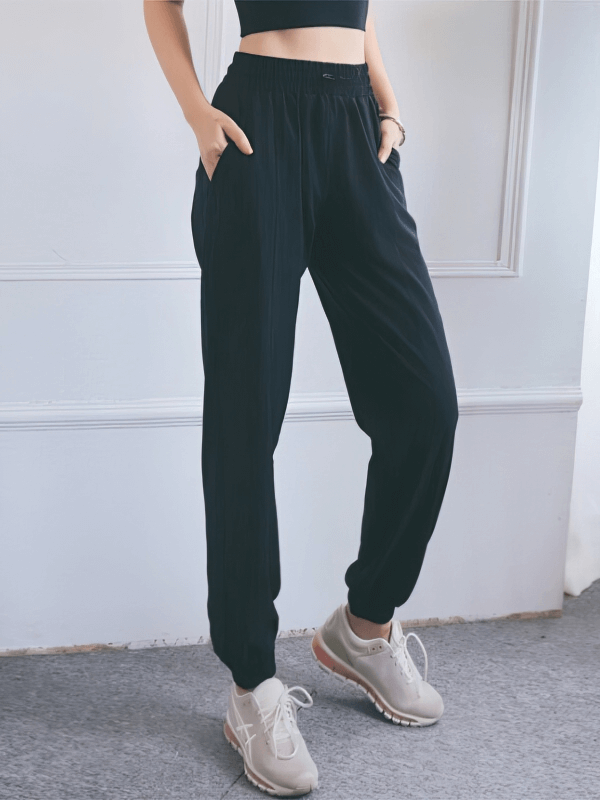 Loose women's high-waisted black yoga training pants with pockets, perfect for comfort and style.