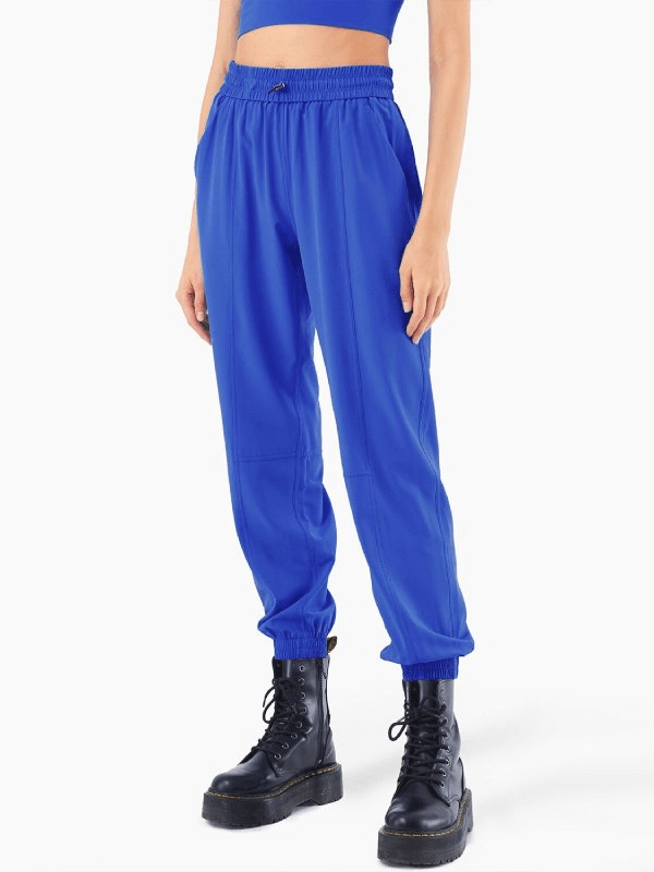 Woman wearing blue high-waisted yoga pants SF0418 with ruffles, paired with black boots. Perfect for comfort and style.