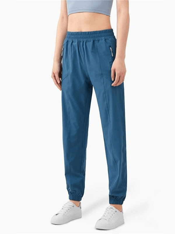 Loose high-waisted yoga training pants in blue with drawstring closure, worn by model, ideal for comfort and style in workouts.