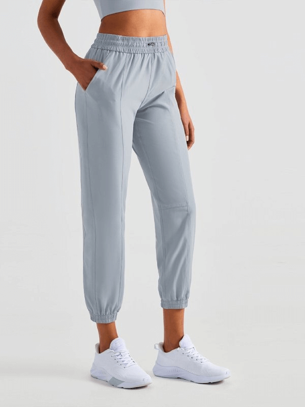 Woman wearing loose high-waisted yoga pants with drawstring closure, perfect for comfort and style in solid color.