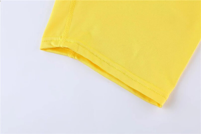 Close-up of yellow male cropped one-leg tights for basketball or football, highlighting fabric detail and color.