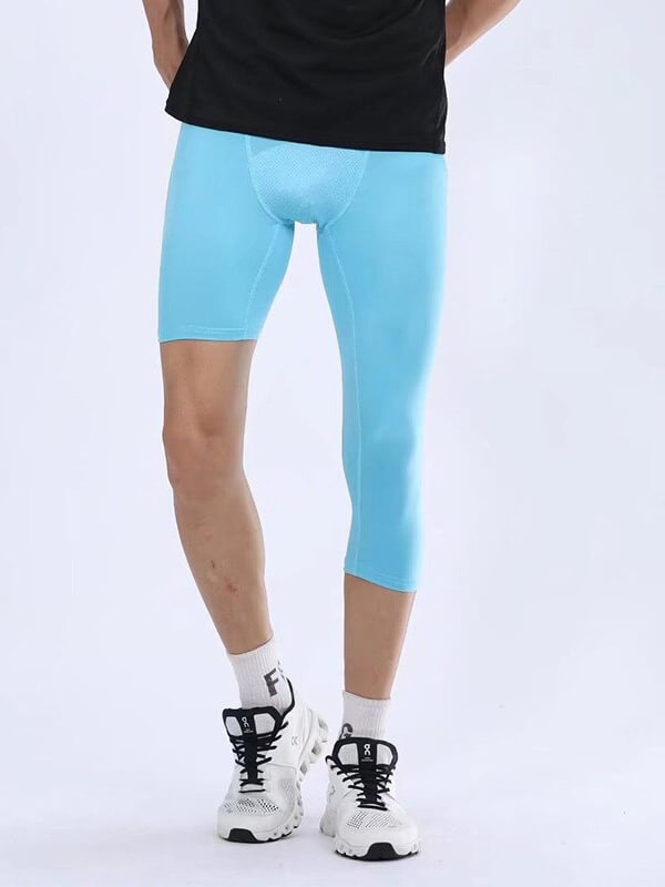 Male athlete wearing blue cropped one-leg tights for basketball or football; high-performance nylon and polyester material.
