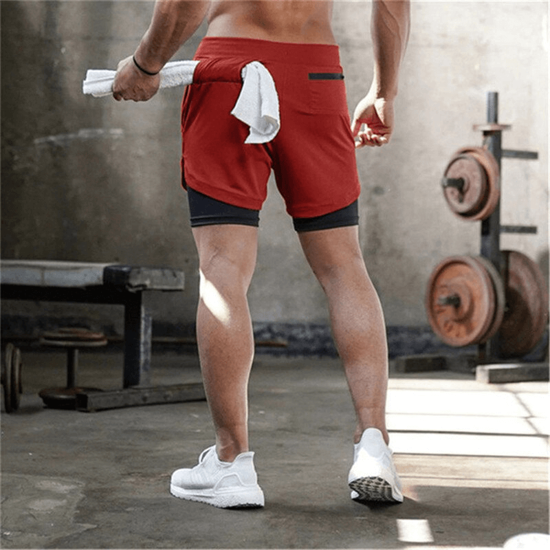 Man wearing red double-deck running shorts with pockets in a gym, showcasing quick-dry fabric and ideal for workouts. SF0939