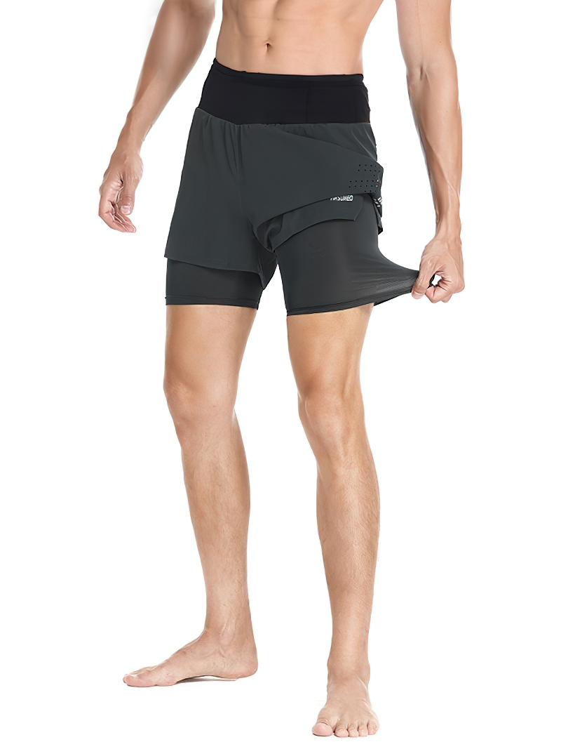 Male wearing black double-layer high waist training shorts for running, featuring elastic waistband and flexible fabric.