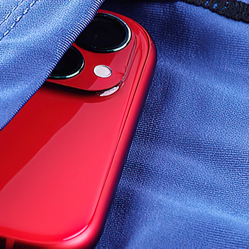 Red smartphone peeking out of a blue fabric pocket, showcasing sleek design and contrast with vibrant colors.