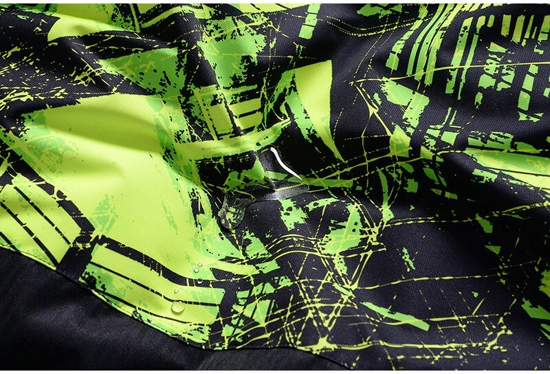 Close-up of a vivid green and black print on a windproof, waterproof ski jacket fabric for men. Stylish and durable design detail.