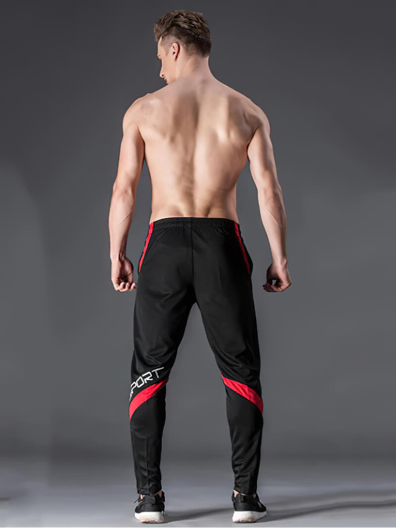 Back view of a male model in sports elastic waist trousers with red stripes, designed for workouts and running.