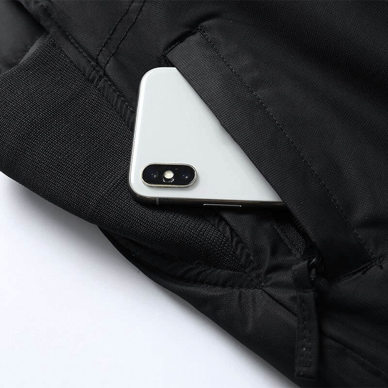 Close-up of snow pants pocket with a smartphone partially visible, highlighting waterproof material and design details.