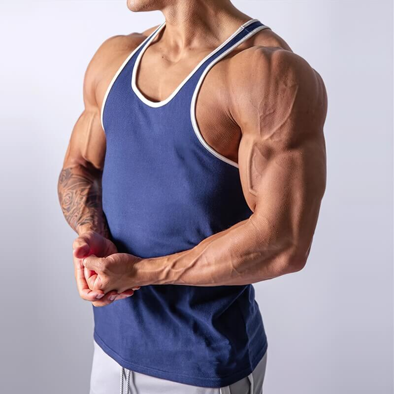 Male bodybuilder wearing a blue cotton tank top for workouts, showcasing muscular arms. Ideal sportswear for comfort and mobility.