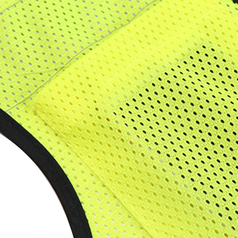 Close-up of a yellow reflective vest made from breathable mesh fabric, designed for high visibility and safety at night.