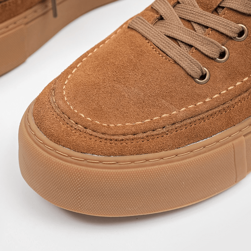 Close-up of men's stylish leather sneakers, showcasing breathable suede design and sturdy rubber outsole for ultimate comfort.