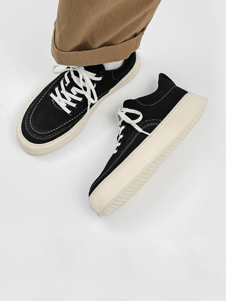 Man wearing men's breathable casual shoes, stylish black leather sneakers with white soles, featuring comfort and flexibility.