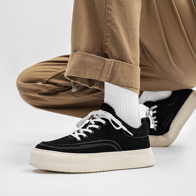 Black men's leather sneakers with white soles, showcasing breathable and stylish design for casual wear.