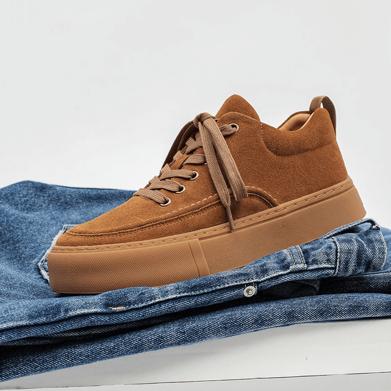 Men's brown leather stylish sneakers with breathable design on folded jeans, perfect for casual style and comfort all day.