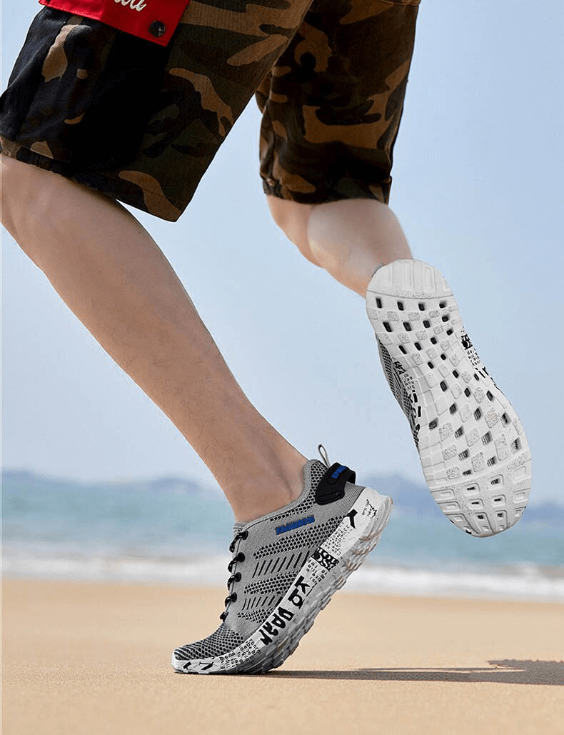 Man running on beach in Men's Casual Lace-Up Mesh Sneakers with Soft Outsole, SF0805, showcasing sporty comfort and style.