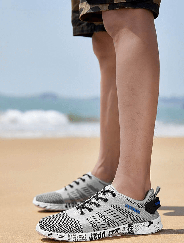 Men's casual mesh sneakers SF0805 on sand, featuring lace-up design and soft outsole for comfort and style at the beach.