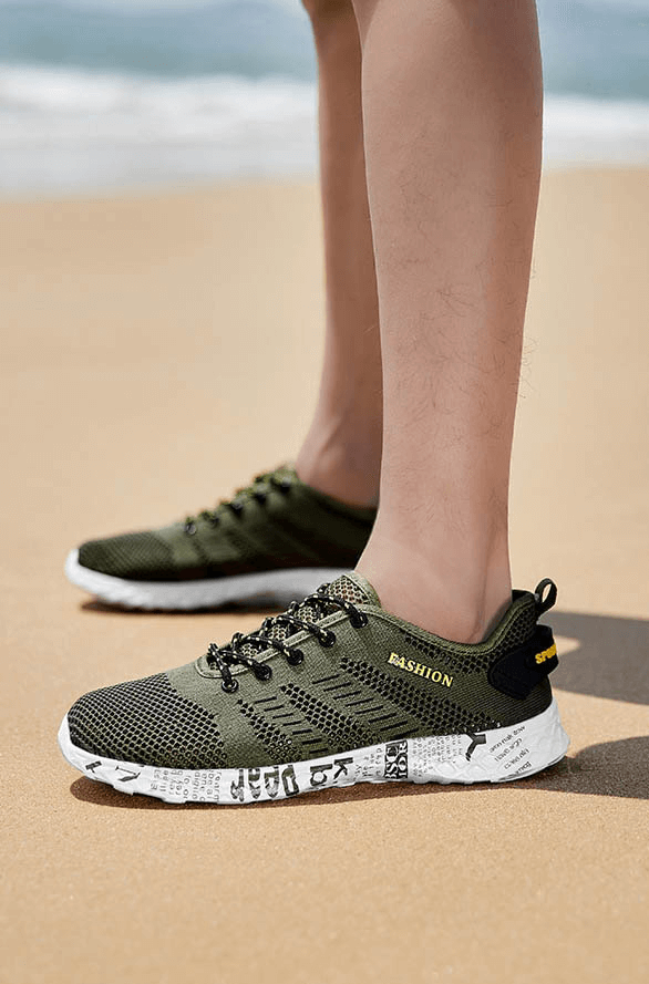 Green men's casual lace-up mesh sneakers with soft outsole on beach, featuring geometric pattern and EVA insole for comfort.