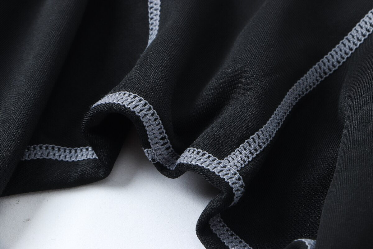 Close-up of black men's compression leggings with gray stitching, perfect for sports and muscle support.