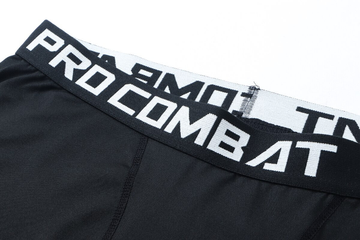 Close-up of men's black compression tights with 'Pro Combat' waistband, perfect for sports and workouts.