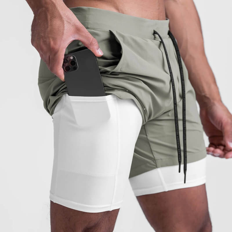 Men's double-layer running shorts with pockets holding a smartphone, showcasing comfort and functionality for sports and fitness.