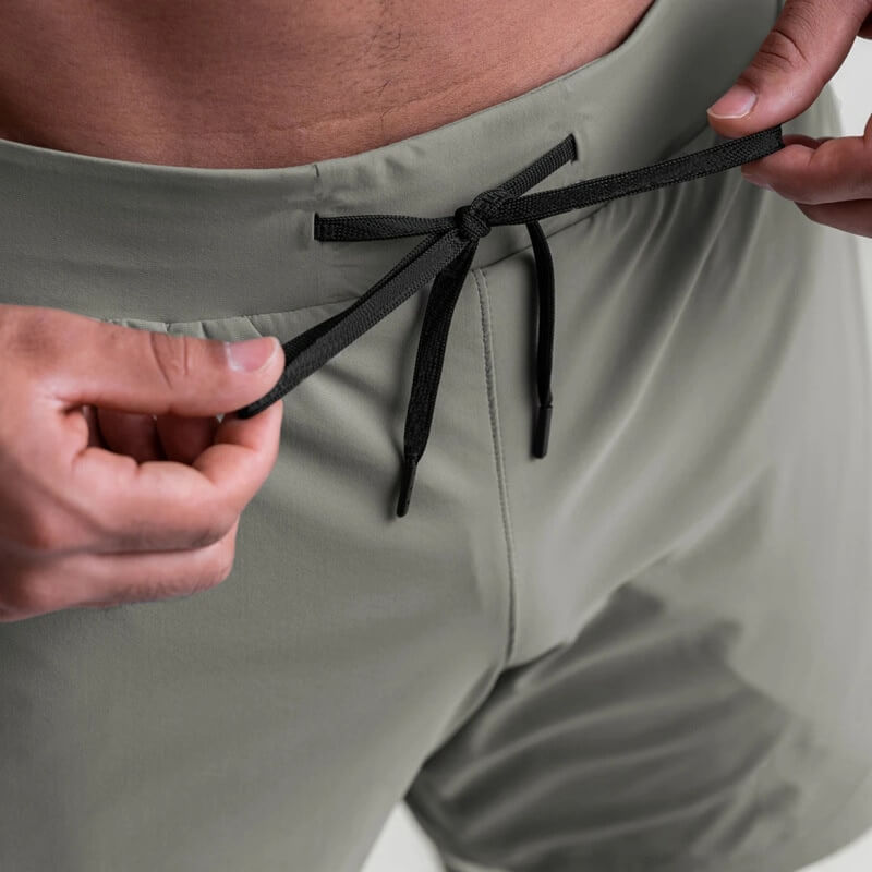 Close-up of men's double-layer sports running shorts in grey with adjustable drawstring, highlighting comfort and style for active wear.