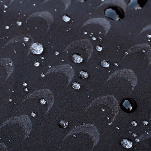 Water droplets on the surface of quick dry, water-repellent fabric of men's swimming shorts showcasing waterproof feature.