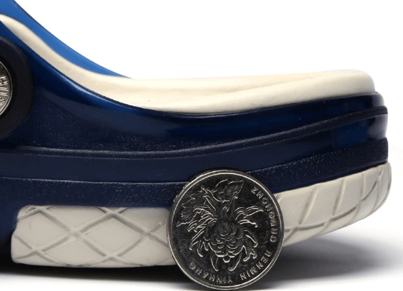 Close-up of a blue and white beach flip flop with a locking strap and a coin for size reference.
