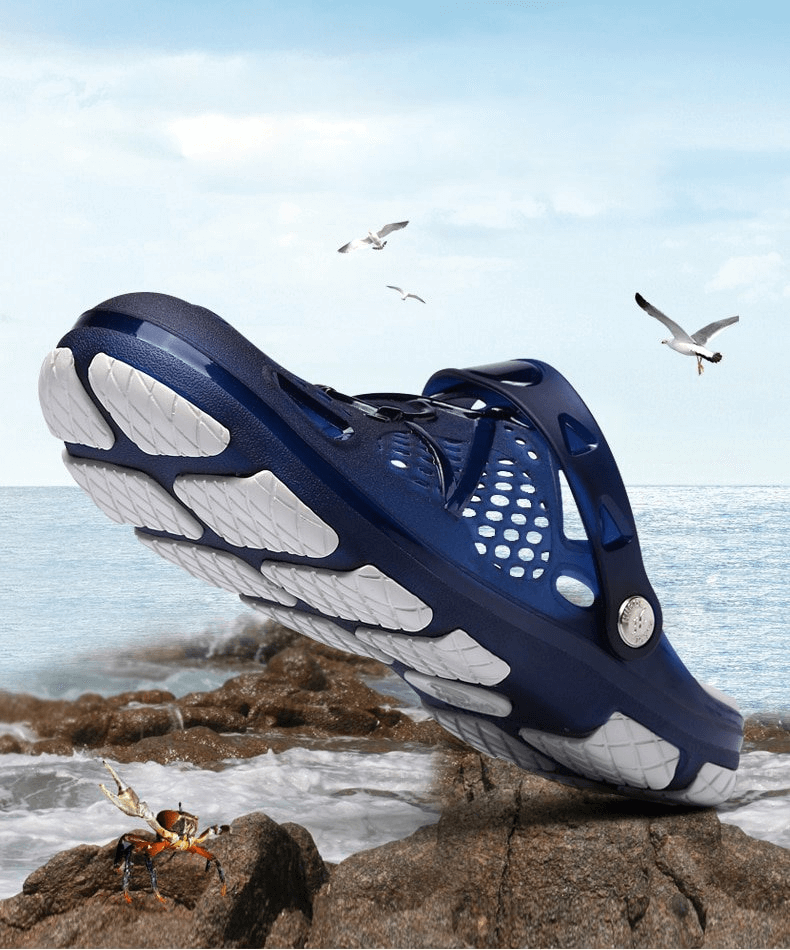 Men's blue lightweight beach flip flops with open heel and locking strap on rocks by the sea, surrounded by seagulls.