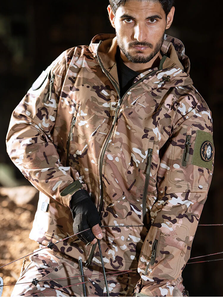 Man wearing men's military tactical warm jacket with hood in camo, ideal for camping and hiking, waterproof and thermal for outdoor adventure.