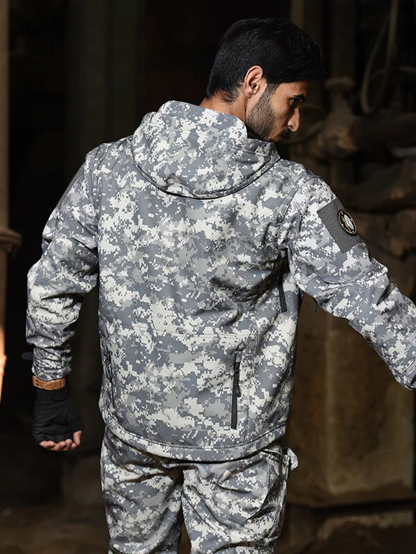 Man wearing a men's military tactical warm jacket with hood and pockets, ideal for outdoor camping and hiking, in camouflage pattern.