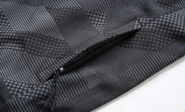 Close-up of the Men's Mountaineering Jacket with patterned fabric and zipper. Quick-drying and windproof material for outdoor adventures.